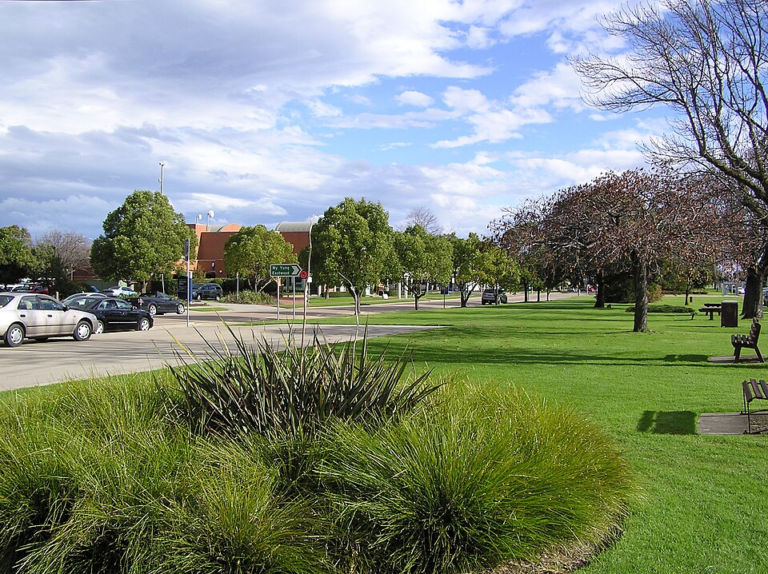 Bairnsdale town centre with park, trees, and parking area